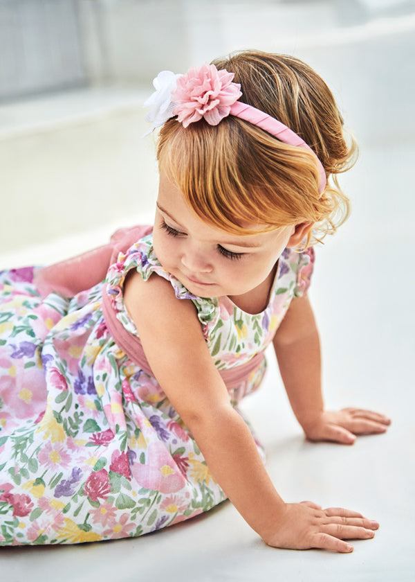 Baby girl wearing baby floral dress with tulle sash