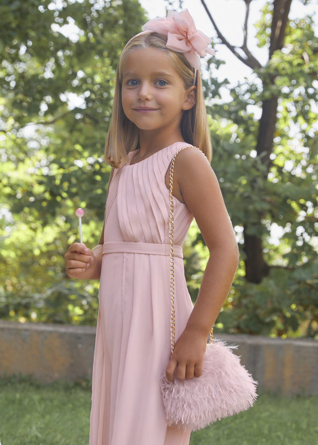 Child holding feather purse in pastel